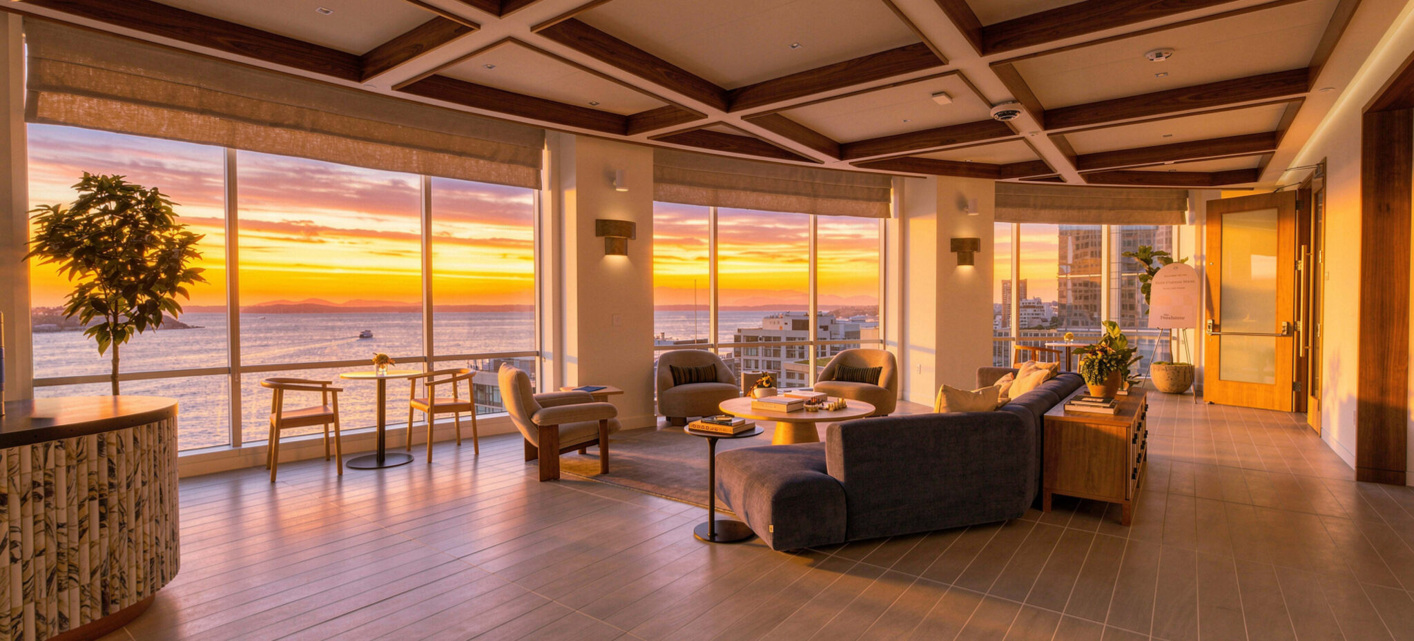 Lounge seating in The Penthouse at sunset, with floor-to-ceiling windows over Puget Sound